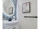 Modern bathroom with a round mirror, updated vanity, and decorative artwork at 912 Pickfair Ter, Lake Mary, FL 32746