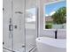 Modern bathroom with a glass-enclosed shower, soaking tub, and views of the outdoors at 912 Pickfair Ter, Lake Mary, FL 32746