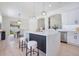 Open concept kitchen features an island with stools, stainless steel appliances, and view of dining area at 912 Pickfair Ter, Lake Mary, FL 32746