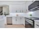 Kitchen with stainless steel dishwasher and sleek white cabinets with black hardware at 912 Pickfair Ter, Lake Mary, FL 32746