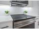 Close up of modern flat top stove with stainless steel oven and sleek white countertops at 912 Pickfair Ter, Lake Mary, FL 32746