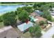 Aerial view of a home with a lake view, backyard pool, mature trees, and landscaping at 9551 Lake Douglas Pl, Orlando, FL 32817
