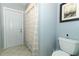 Bathroom with a white shower curtain and a toilet next to a door, offering a functional and clean space at 9551 Lake Douglas Pl, Orlando, FL 32817