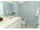 Light blue bathroom with a white vanity, tile floors, and white towels, offering a clean and functional space at 9551 Lake Douglas Pl, Orlando, FL 32817