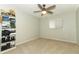 This bedroom has neutral walls and carpeting, a closet shelving unit, and a fan providing comfort and storage at 9551 Lake Douglas Pl, Orlando, FL 32817