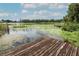 Close-up of a rustic wooden dock on a serene lake, perfect for enjoying the natural surroundings at 9551 Lake Douglas Pl, Orlando, FL 32817