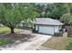Charming single-story home with a well-maintained lawn and long driveway at 9551 Lake Douglas Pl, Orlando, FL 32817