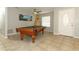 Spacious game room featuring a billiard table, surfboard, and a coastal-themed artwork, perfect for entertainment at 9551 Lake Douglas Pl, Orlando, FL 32817