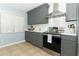 A modern kitchen with grey cabinets, stainless steel appliances, and a white subway tile backsplash at 9551 Lake Douglas Pl, Orlando, FL 32817
