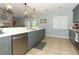 Updated kitchen features gray cabinetry, stainless steel appliances, and pendant lighting at 9551 Lake Douglas Pl, Orlando, FL 32817