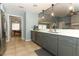 A modern kitchen with grey cabinets, stainless steel appliances, and an open view into the other room at 9551 Lake Douglas Pl, Orlando, FL 32817