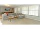 Inviting living room featuring a gray sectional, a surfboard, and a view of the pool table for relaxation and entertainment at 9551 Lake Douglas Pl, Orlando, FL 32817
