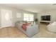 Bright living room with a comfortable gray sofa, plush cushions, and natural light streaming through the windows at 9551 Lake Douglas Pl, Orlando, FL 32817