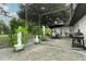 Large covered patio with a screen enclosure, showcasing patio furniture, hanging plants, and an outdoor grill at 9551 Lake Douglas Pl, Orlando, FL 32817