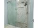 Modern shower with glass door, rainfall shower head, and tiled surround at 9551 Lake Douglas Pl, Orlando, FL 32817