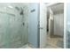 Modern shower with glass door, rainfall shower head, and tiled surround at 9551 Lake Douglas Pl, Orlando, FL 32817
