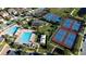 Aerial view of tennis courts and a community pool surrounded by manicured landscaping and residences at 10072 Sunnifa Aly, Orlando, FL 32832