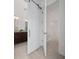 Bathroom with a barn door, granite countertop, and dark cabinets offering style and function at 10072 Sunnifa Aly, Orlando, FL 32832