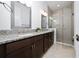 Modern bathroom with double vanity, granite countertop, framed mirrors, and glass shower at 10072 Sunnifa Aly, Orlando, FL 32832