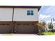 Exterior view of a townhome featuring a two-car garage and neutral paint with well-kept landscaping at 10072 Sunnifa Aly, Orlando, FL 32832