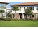 Charming townhome exterior featuring manicured landscaping, stone accents, and a well-maintained lawn at 10072 Sunnifa Aly, Orlando, FL 32832