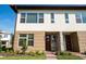 Modern townhome showcasing clean lines, a contemporary color scheme, and well-maintained front yard at 10072 Sunnifa Aly, Orlando, FL 32832