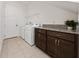 Laundry room features tile floors, a countertop with storage, and modern washer and dryer at 10072 Sunnifa Aly, Orlando, FL 32832