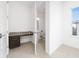 Room featuring a small built-in desk with granite countertop, tile floors, and attached half bathroom at 10072 Sunnifa Aly, Orlando, FL 32832