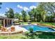 Resort style backyard featuring a pool, spa, multiple seating areas, and mature landscaping at 105 Laurel Oak Dr, Longwood, FL 32779