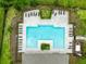 Overhead drone shot showcases an inviting rectangular pool lined with gray stone, surrounded by lounge chairs and lush greenery at 12216 Encore At Ovation Way, Winter Garden, FL 34787