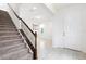 Inviting entryway featuring a carpeted staircase, wood railing, and light tile flooring leading to a bright living space at 12216 Encore At Ovation Way, Winter Garden, FL 34787