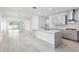 Spacious open-concept kitchen with gray cabinets, white quartz island, and stainless steel appliances overlooking the living area at 12216 Encore At Ovation Way, Winter Garden, FL 34787
