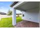 Covered patio features brick floor, white posts, and a view of the landscaped backyard at 12216 Encore At Ovation Way, Winter Garden, FL 34787