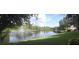 Expansive view of a pond with a fountain, framed by trees and manicured grassy shorelines at 13584 Turtle Marsh Loop # 12, Orlando, FL 32837