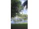 Picturesque pond with a central water fountain surrounded by lush trees and green grass at 13584 Turtle Marsh Loop # 12, Orlando, FL 32837