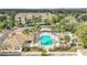 Stunning aerial view of the community pool and hot tub with a recreation center surrounded by trees at 13584 Turtle Marsh Loop # 12, Orlando, FL 32837