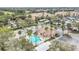 Aerial view of a community pool and clubhouse, surrounded by palm trees and parking at 13584 Turtle Marsh Loop # 12, Orlando, FL 32837