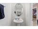 Tasteful bathroom with pedestal sink, white walls, oval mirror, and a plush hand towel at 148 Miro Dr, Davenport, FL 33837
