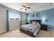 Bedroom featuring a blue accent wall, queen bed, ceiling fan and window with curtains at 148 Miro Dr, Davenport, FL 33837