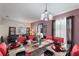 Open dining room with contemporary decor, dark table with red covered chairs, and chandelier at 148 Miro Dr, Davenport, FL 33837