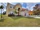 Charming two-story home featuring a red tile roof, arched entryway, manicured lawn, and a two-car garage at 148 Miro Dr, Davenport, FL 33837