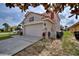 Charming two-story home featuring a red tile roof, arched entryway, manicured lawn, and a two-car garage at 148 Miro Dr, Davenport, FL 33837