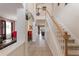 Bright, two-story foyer featuring tile flooring, stairway, and views into other rooms of the house at 148 Miro Dr, Davenport, FL 33837