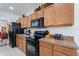 Functional kitchen featuring modern black appliances, wooden cabinets, and adjacent dining area at 148 Miro Dr, Davenport, FL 33837