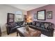 Comfortable living room with dark leather sofas, decorative pillows, and a unique coffee table at 148 Miro Dr, Davenport, FL 33837