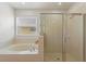 Well-lit main bathroom with separate shower, soaking tub, and neutral tile at 148 Miro Dr, Davenport, FL 33837