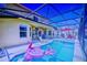 Screened-in pool area with an outdoor dining set and lounge chairs, and inflatable pink flamingos at 148 Miro Dr, Davenport, FL 33837