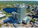 Stunning aerial view of building, city, and lake, with pool, tennis courts, and green surroundings at 150 E Robinson St # 407, Orlando, FL 32801
