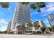 Modern high-rise building with palm trees, landscaping, and convenient parking garage access at 150 E Robinson St # 407, Orlando, FL 32801