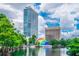 Lake view of a modern high-rise building in a green setting, next to an interesting structure at 150 E Robinson St # 407, Orlando, FL 32801
